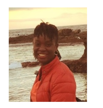 Dr. Ibukun Akinrinade pose in front of a beach. She wears an orange jacket.