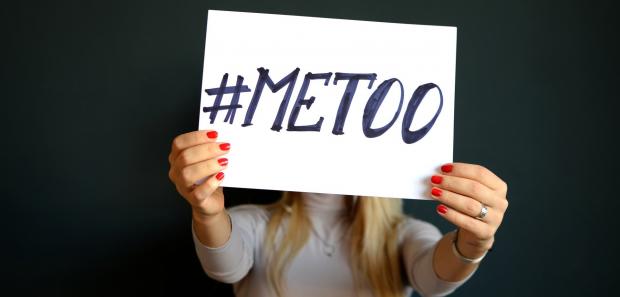 a women holding a paper with "#METOO# writed on