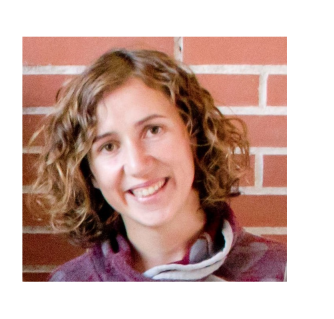 Dr Castillo poses in front of a brick wall, she has short surly hair and smiles widly