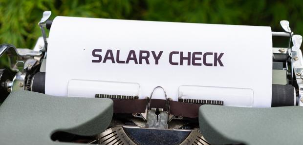 Typewriter with a piece of paper spelling "Salary Check"