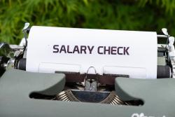 Typewriter with a piece of paper spelling "Salary Check"