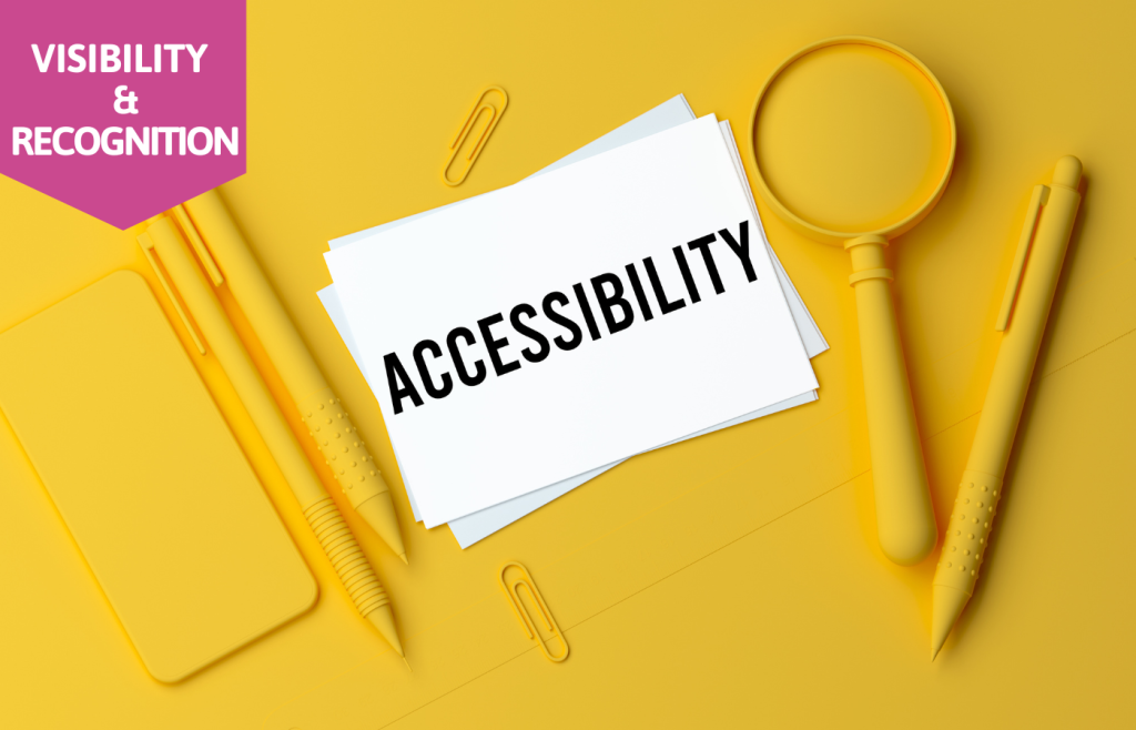 white card with the word "accessibility" written in black on a yellow desktop with yellow office supplies